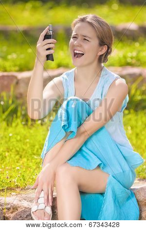 Dissapointed And Angry Young Caucasian Woman Shouting At Her Cellphone. Sitting On The Ground Agains
