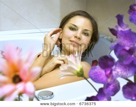 ผู้หญิงในห้องน้ำด้วยกลีบของดอกไม้
