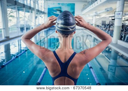 Pretty swimmer standing by the pool at the leisure center