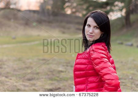 beautiful young girl in a forest in red jacket