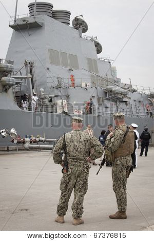 STATEN ISLAND, NY - MAY 21, 2014: Armed U.S. Navy personnel patrol Sullivans Piers while the guided-missile destroyer USS Cole (DDG 067) is docked during Fleet Week NY on May 21, 2014.