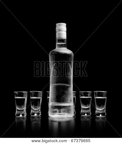 Bottle And Glasses Of Vodka Standing Isolated On Black Background