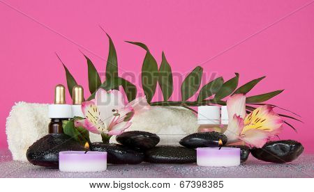 Candle, flower, stones, before a howea leaf