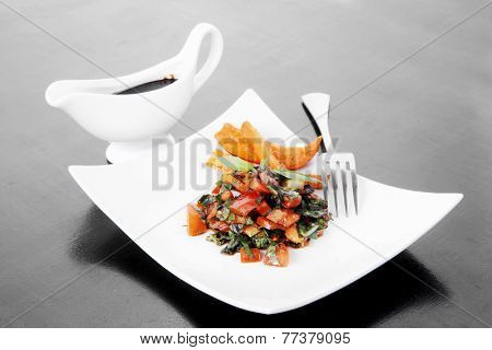 vegetable salad : cherry tomatoes and basil with sweet baked potato served on white plate with sauceboat full blask soy sauce on wood