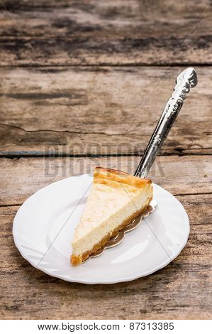 Piece Of Cheesecake With Cake Server On Wooden Table