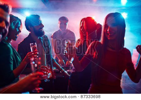 Happy friends toasting at night party
