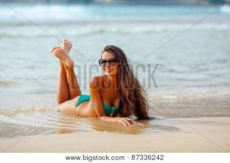 tanned brunette laying on the beach