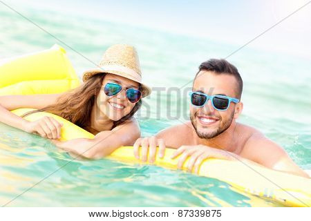 A picture of a young couple having fun on a matress in the Baltic Sea