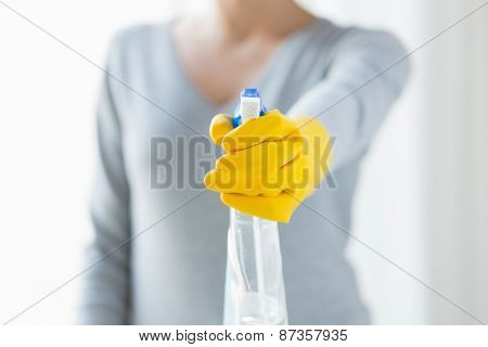 people, housework and housekeeping concept - close up of happy woman with cleanser spraying home