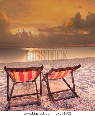 Couples Of Wood Chairs Beach At Sea Side And Parashoot Ship Playing Over Sun Set Sky