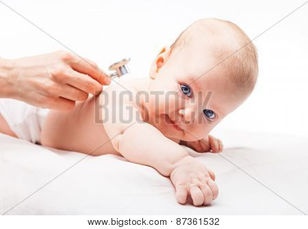 Close-up shot of pediatrician examines three month baby girl. Doctor using a stethoscope to listen to baby's back checking heart beat. Child is looking at camera