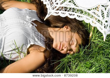 草の上の白い睡眠のきれいな女の子