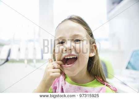 Girl Showing Her Healthy Milk Teeth At Dental Office
