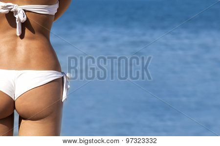 Beautiful girl buttocks on a blue sea background