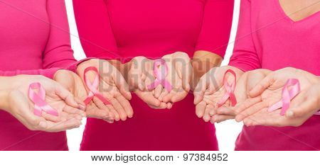 healthcare, people and medicine concept - close up of women in blank shirts with pink breast cancer awareness ribbons over white background