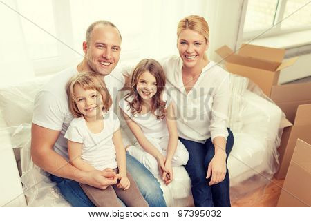 family, children, accommodation and home concept - smiling parents and two little girls moving into new home