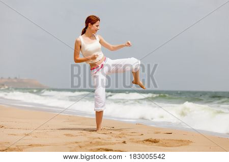 photo of beautiful young woman doing joga on the wonderful see and sky background