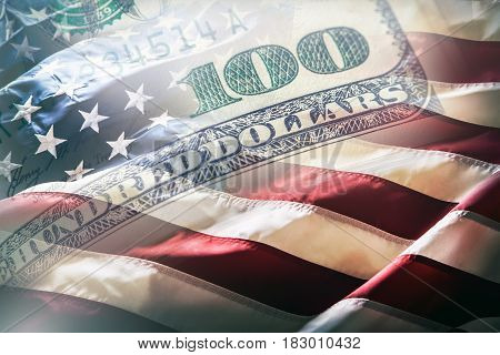USA flag and American dollars. American flag blowing in the wind and 100 dollars banknotes in the background.