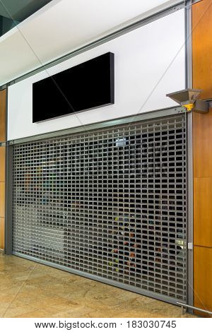 Mockup signboard. Closed shop with roller shutter in shopping center