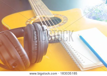 Guitar and Headphone with notebook for songwriting