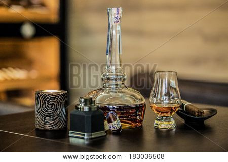 Bottle and glass of whiskey with wooden background.