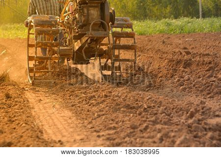 Man working in the garden with garden tiller. Garden tiller to work.