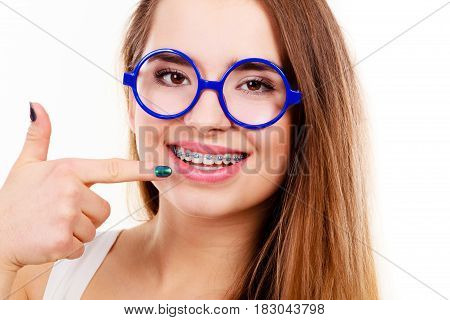 Dentist and orthodontist concept. Nerdy geek woman wearing big eyeglasses smiling showing her white teeth with blue braces