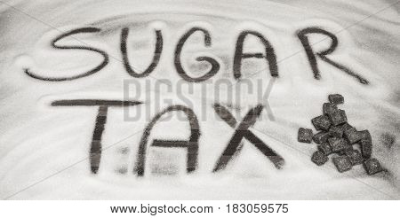 Sugar tax sign with sugar cubes in front