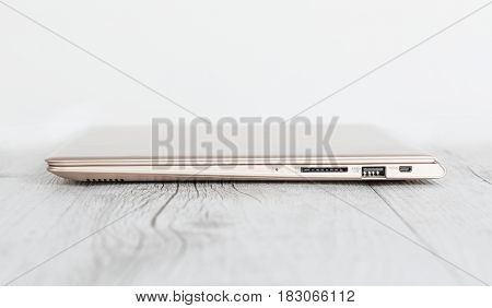 Ultra-thin notebook. The gold notebook on the desk the notebook lies on a wooden background.
