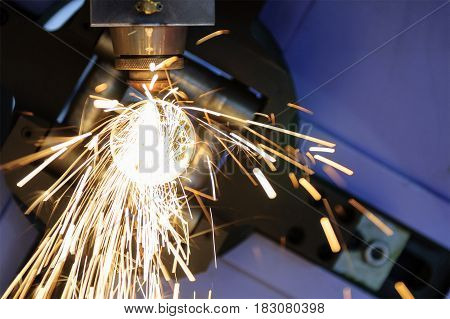 The CNC laser cut machine while cutting the steel tube with the sparking light.The hi-precision tube cutting process by laser cut