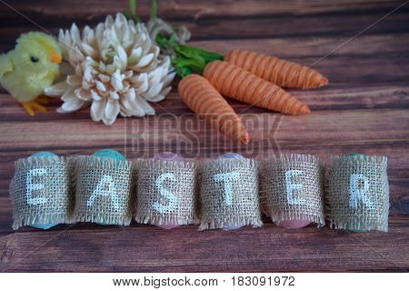Easter concept: inscription Easter consisting on sacking. On wooden background waith copy space