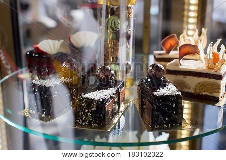 Close up shot of delicious pastry on glass showcase in patisserie.