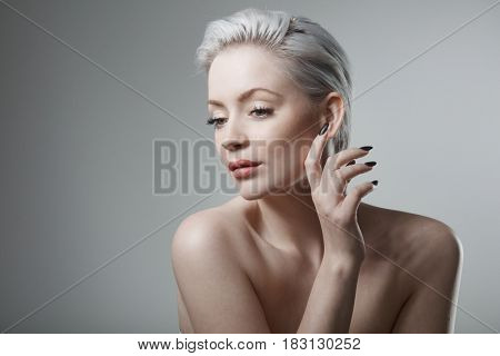 Sensual young woman with short hair and black nails.