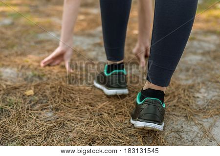 Girl In Sports Pants And Shoes, Stands At The Start Before Running, Leaning Hands, On The Nature.