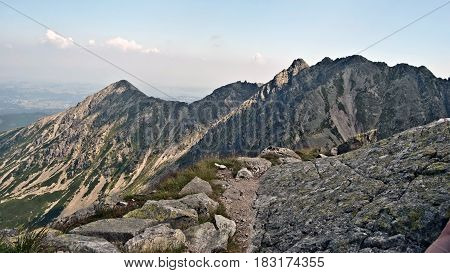view from Orla Perc hiking trail in polish part of High Tatras mountains with peaks and blue sky with few clouds
