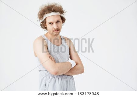 Nice curly man in gey shirt and pants on waist. Retro style photo. Sport concept