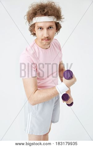 Top view of retro man in funny sportswear building arm muscles working out with bars