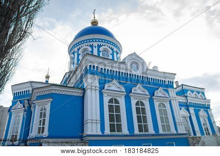 Old blue-white church with blue sky and clouds