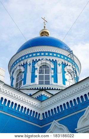 Old blue-white church with blue sky and clouds