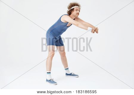 Nice sporty man in jumpsuit stretching back with hands forward. Looking fresh and rested