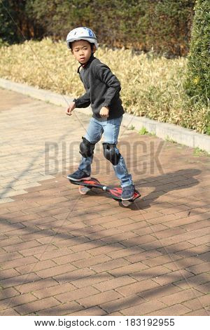 Japanese Boy Riding On A Casterboard (first Grade At Elementary School)