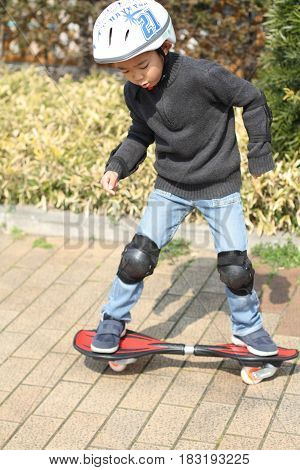 Japanese Boy Riding On A Casterboard (first Grade At Elementary School)
