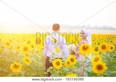 Smiling Young Islamic Couple Portrait On Sunflowers Field