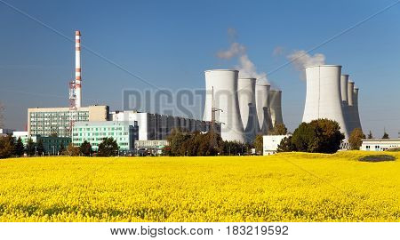 Panoramic view of Nuclear power plant Jaslovske cooling tower Bohunice with golden flowering field of rapeseed - Slovakia - two possibility for production of electric energy
