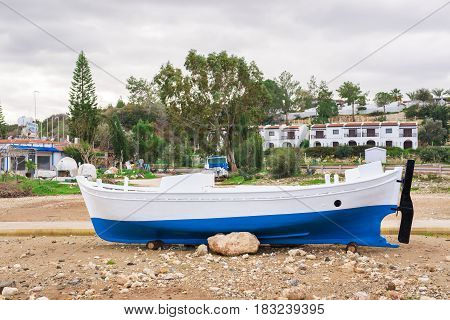 The boat are aground in shallow sea water. Ship run aground in waterless pier or harbor