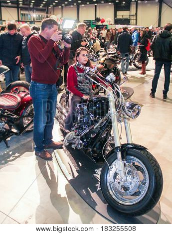 St. Petersburg Russia - 15 April, A girl is photographed on a motorcycle,15 April, 2017.
International Motor Show IMIS-2017 in Expoforurum.
Visitors and participants of the annual moto-salon in St. Petersburg.