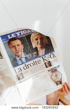 PARIS FRANCE - APR 24 2017: Emmanuel Macron on newspaper cover - woman reading the French newspaper Le Figaro a day after the first round of the French Presidential election on April 24 2017