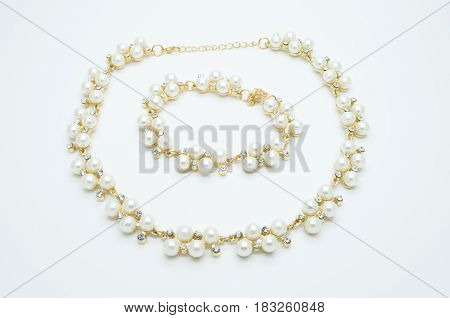 on a white background lies a pearl necklace on the neck and bracelet precious as a gift beloved woman