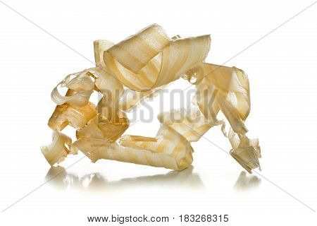Light brown wood shavings from carpenter's hand planer or chisel work on wooden boards on white background with selective focus