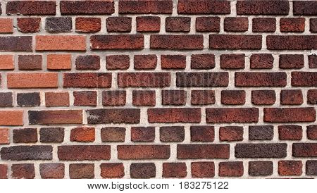 Portion of a brick wall with different colored bricks